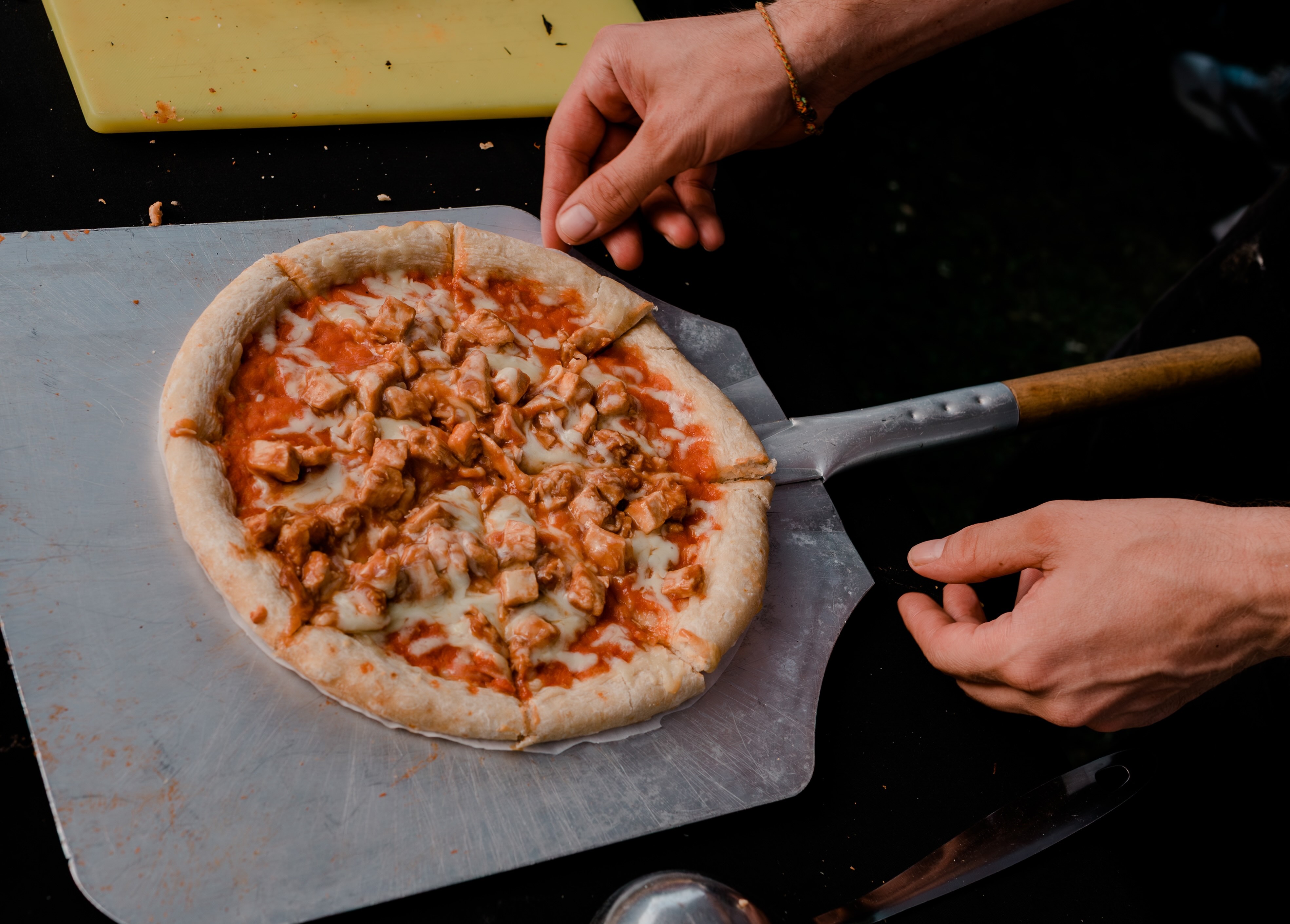 Fresh wood-fired pizza being served during a wedding celebration